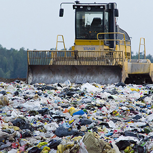 A bull dozer on garbage-covered landfill
